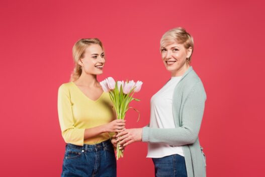 Datter der giver sin mor en buket blomster på mors dag